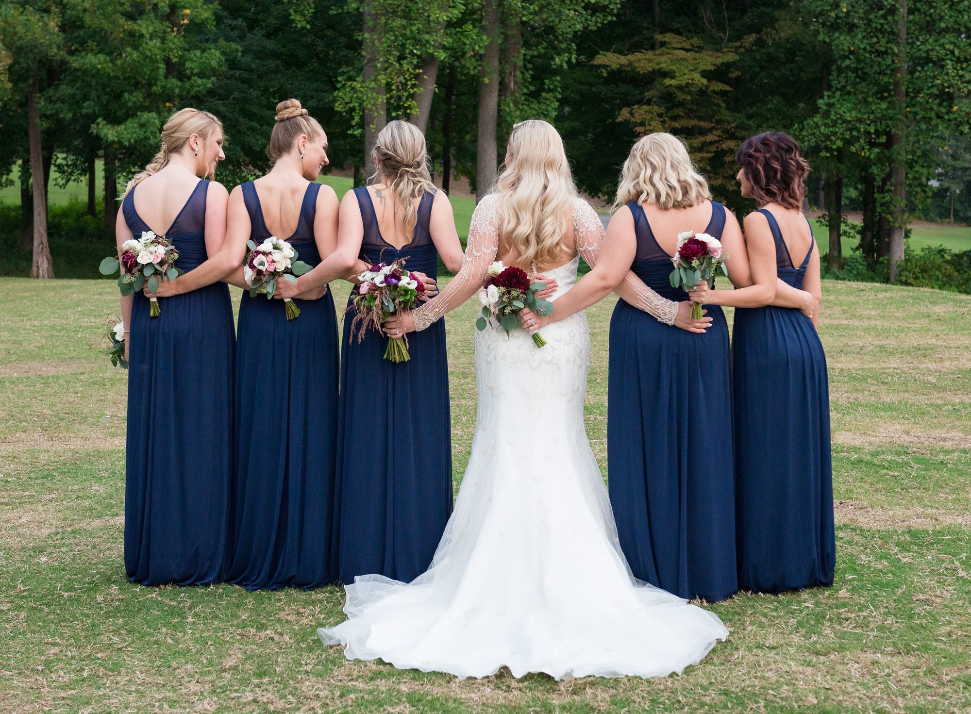 bride with bridesmaids in long navy gowns