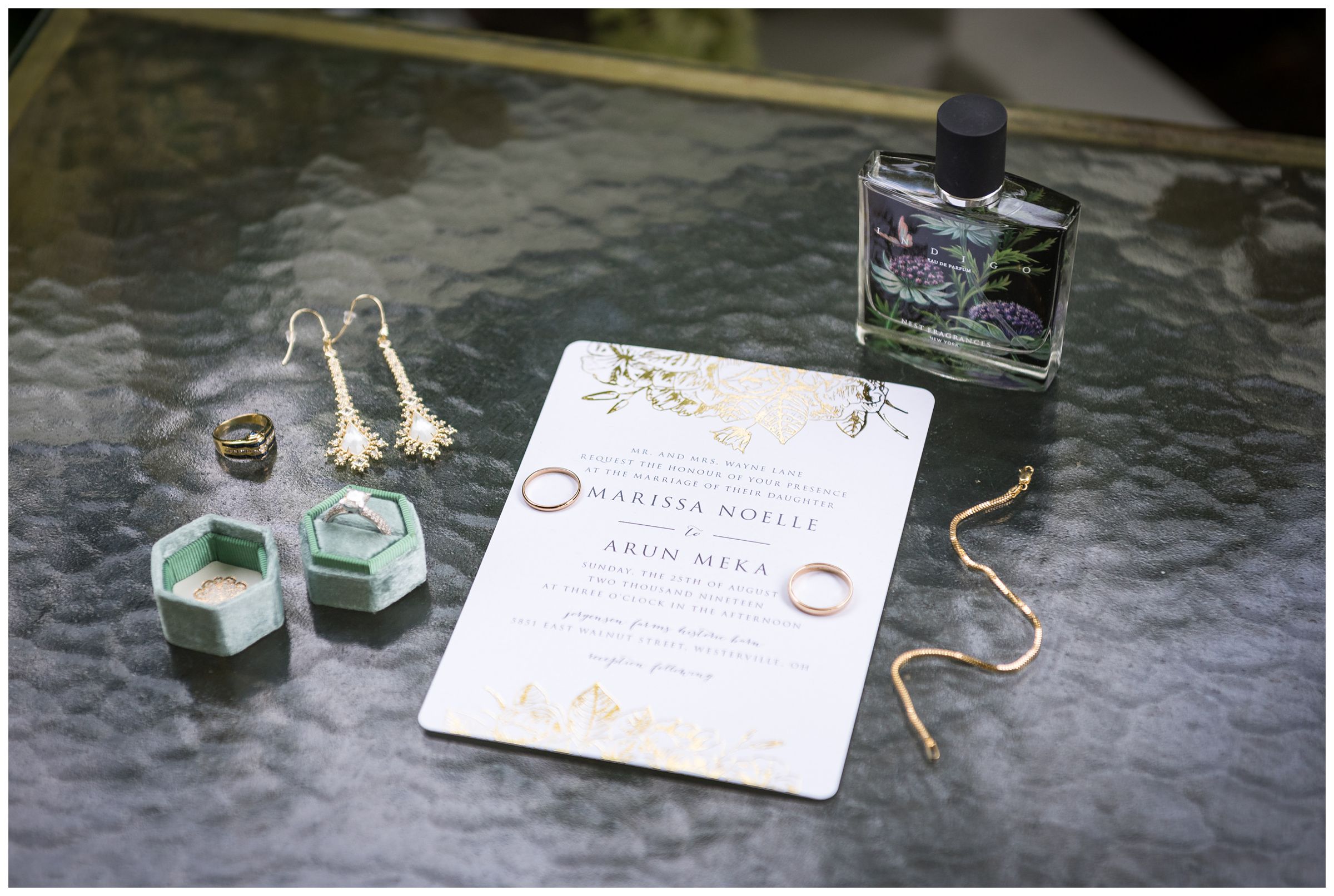 bridal detail photo of bride's gold jewelry, wedding rings with aqua velvet ring box, and nest indigo perfume