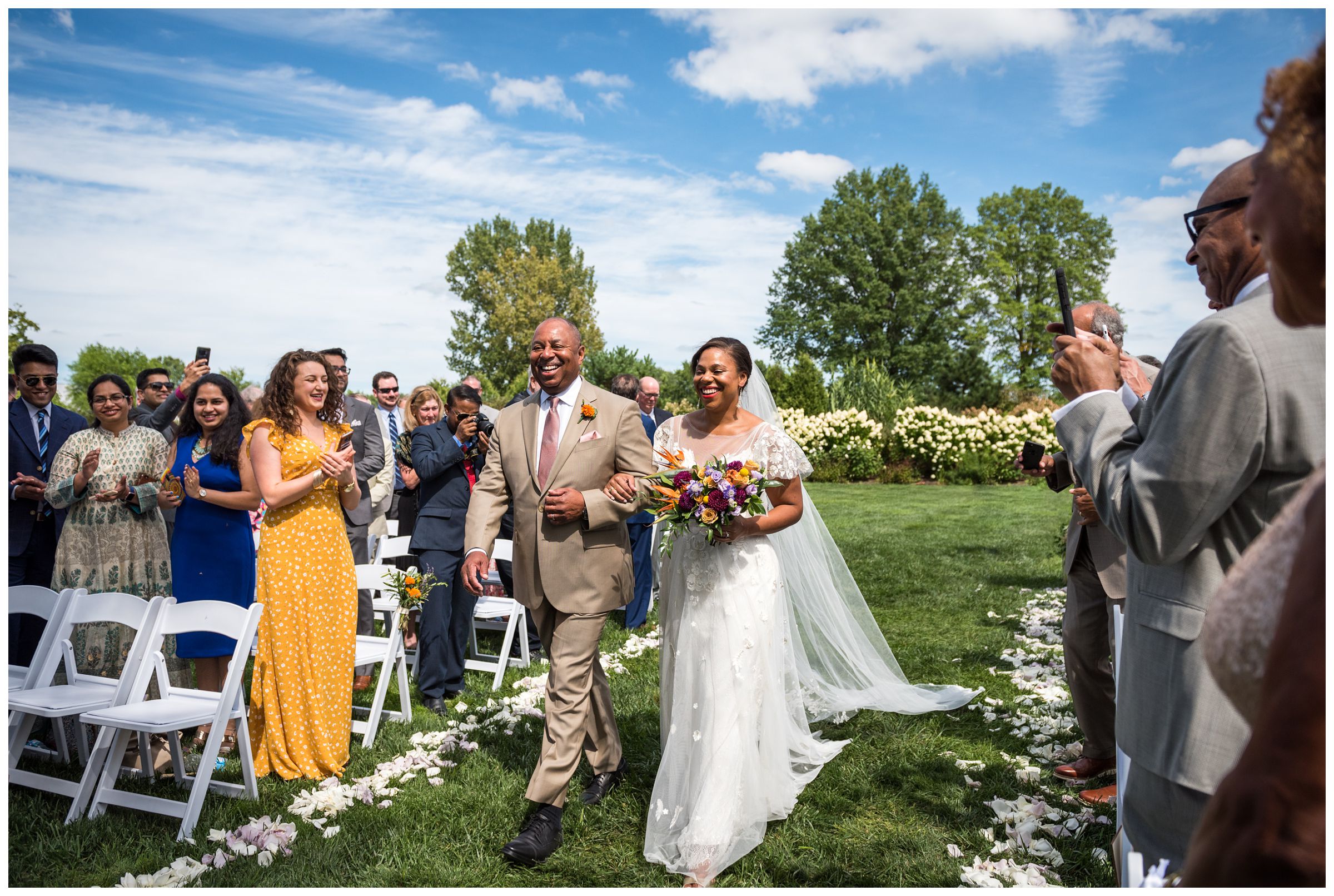 African American bride walking down aisle with father during summer Jorgensen Farms wedding