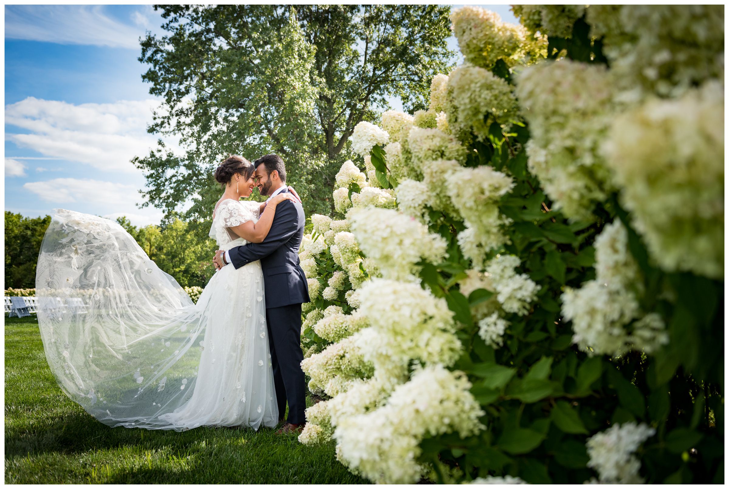 groom and bride with flowy lace wedding dress portrait with hydrangeas at Jorgensen Farms