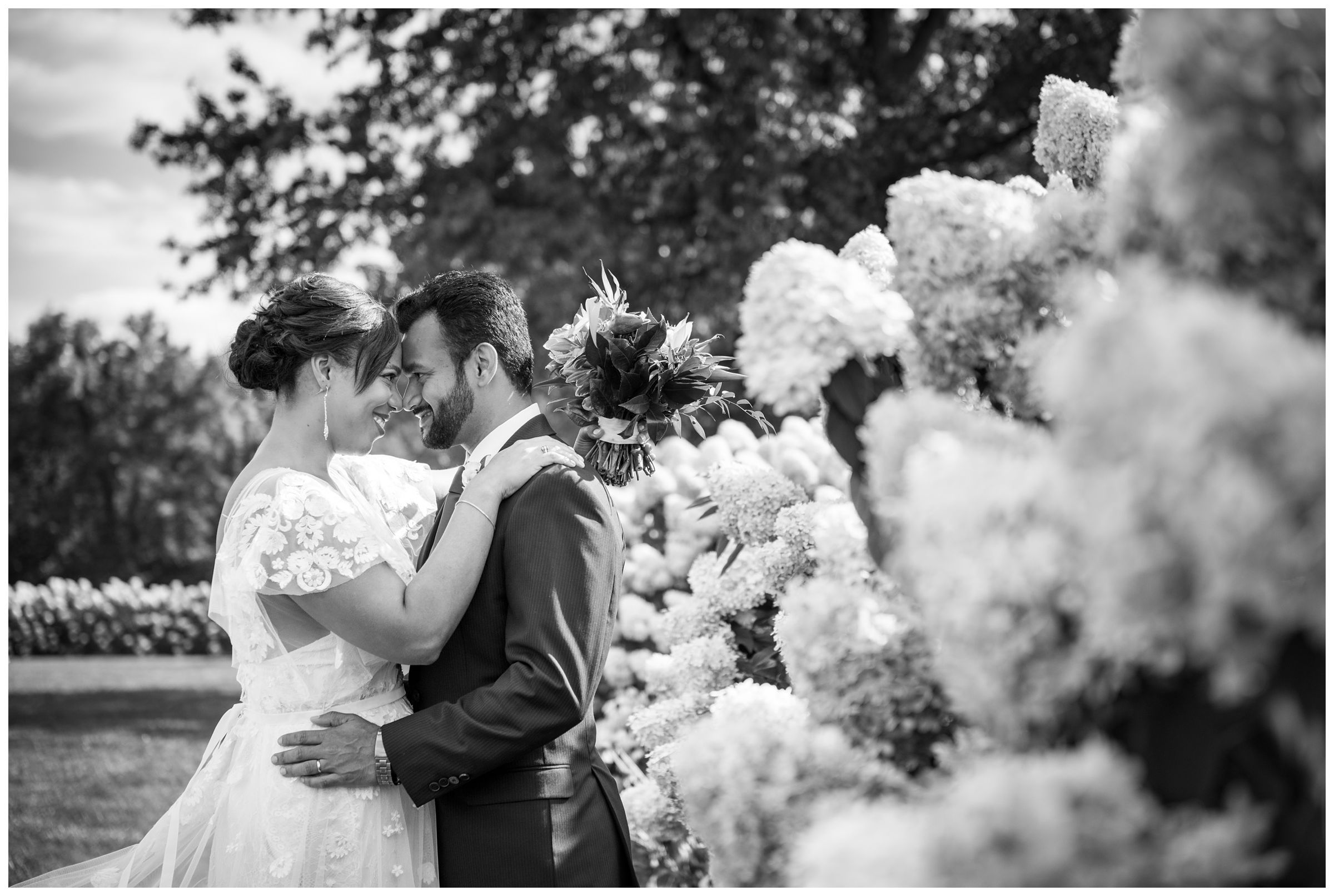 bride and groom with hydrangeas in flower field at Jorgensen Farms wedding venue