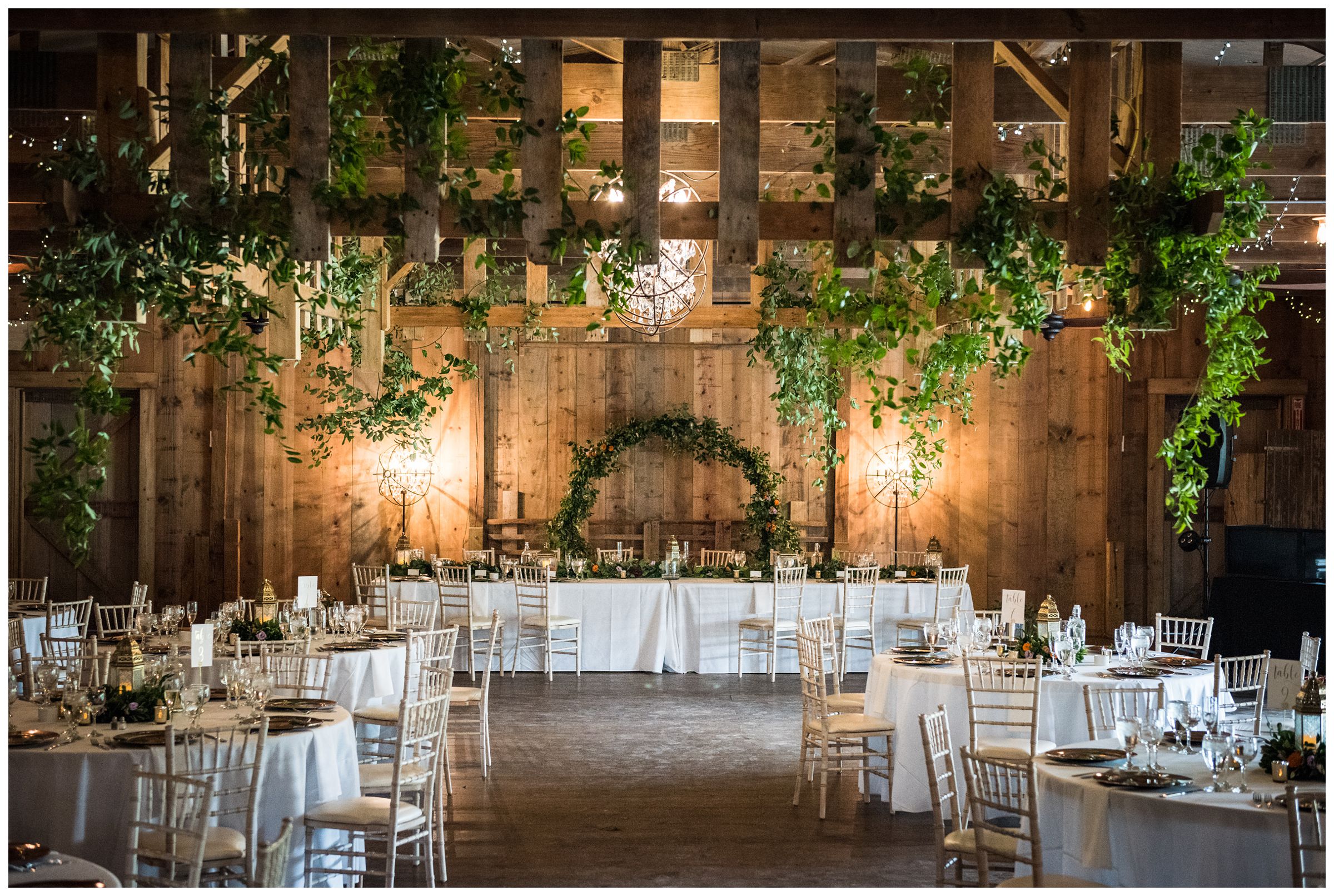 Jorgensen Farms Historic Barn wedding reception with greenery and gold decor