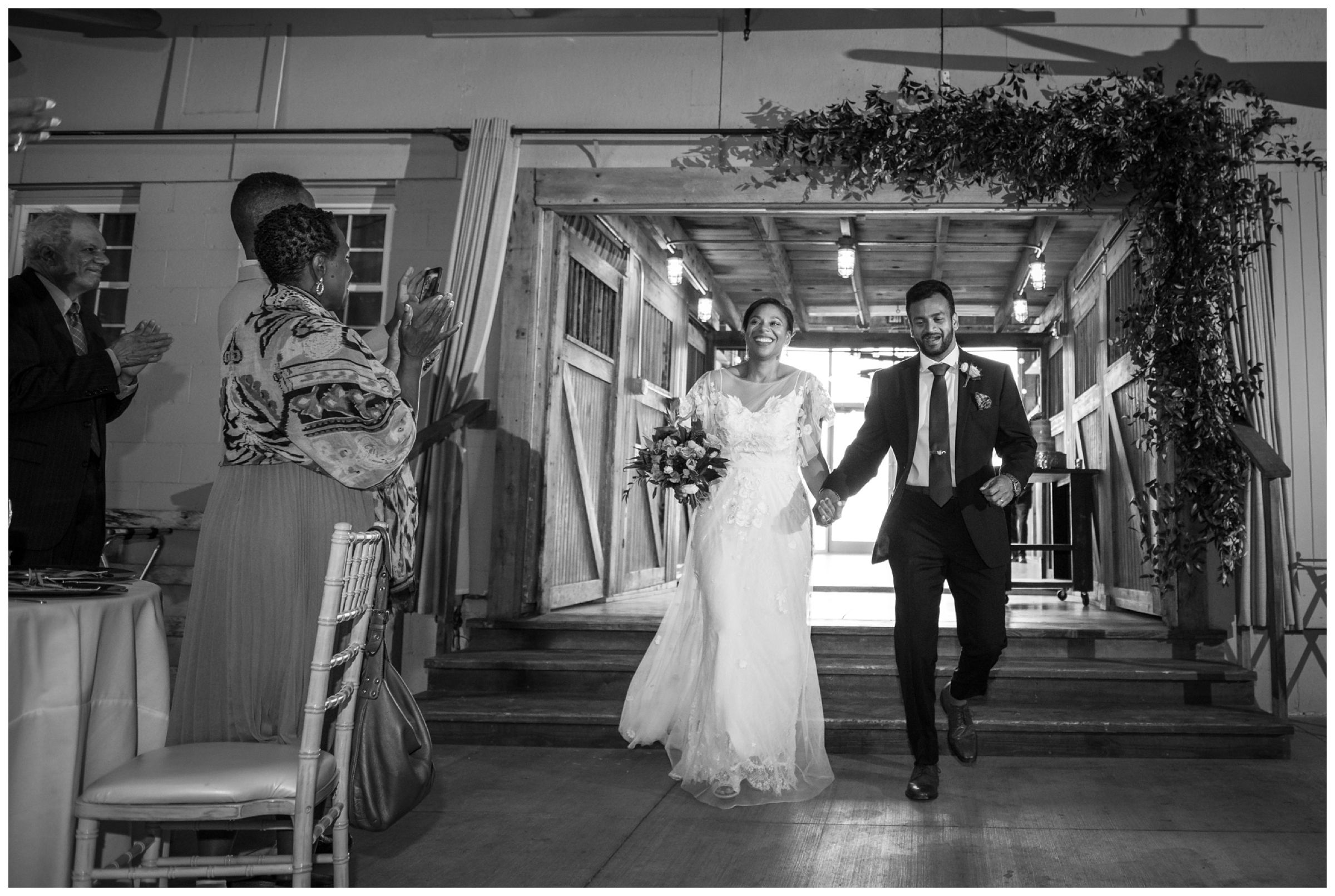 bride and groom entering wedding reception at rustic barn wedding