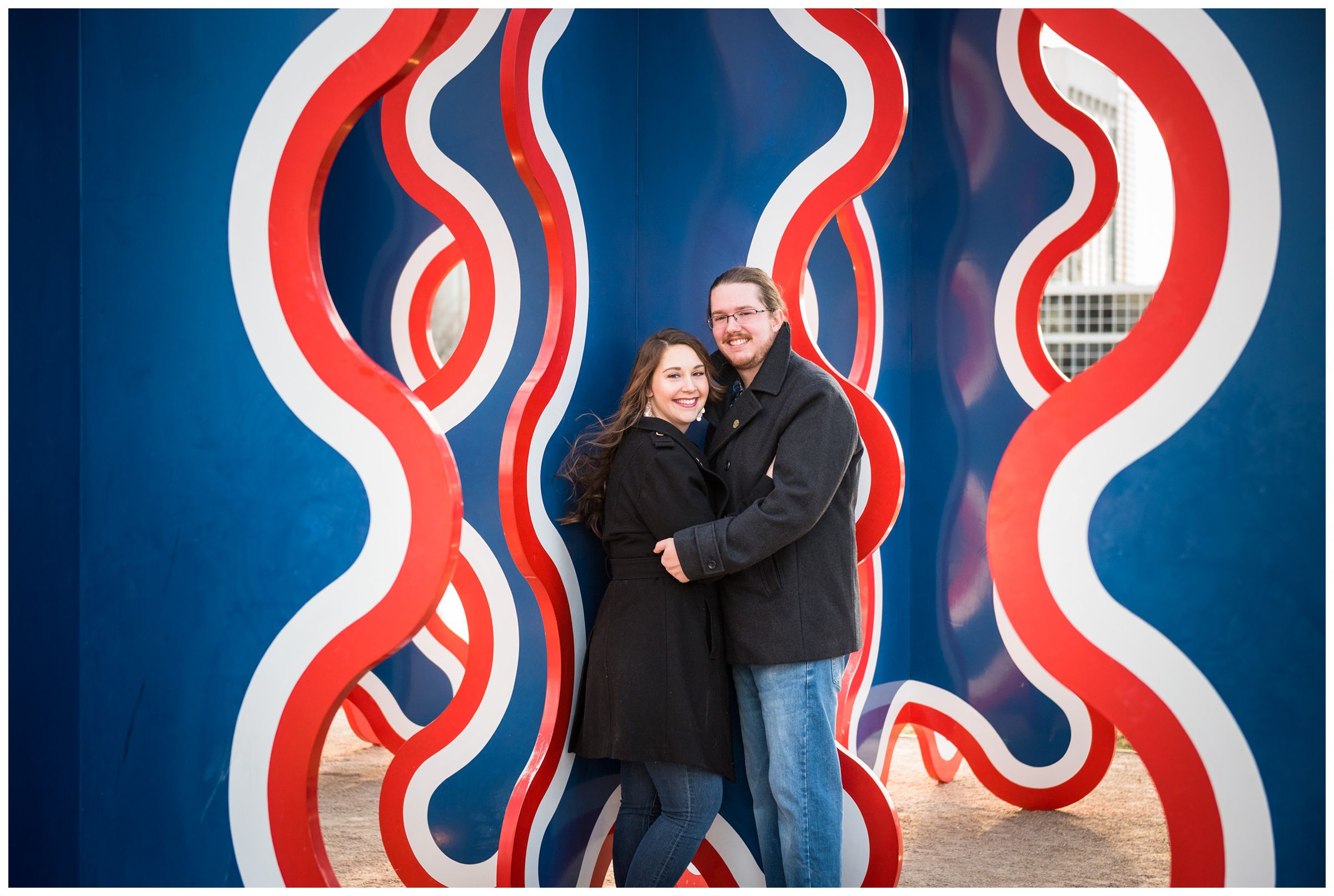 couple in front of blue and orange sculpture