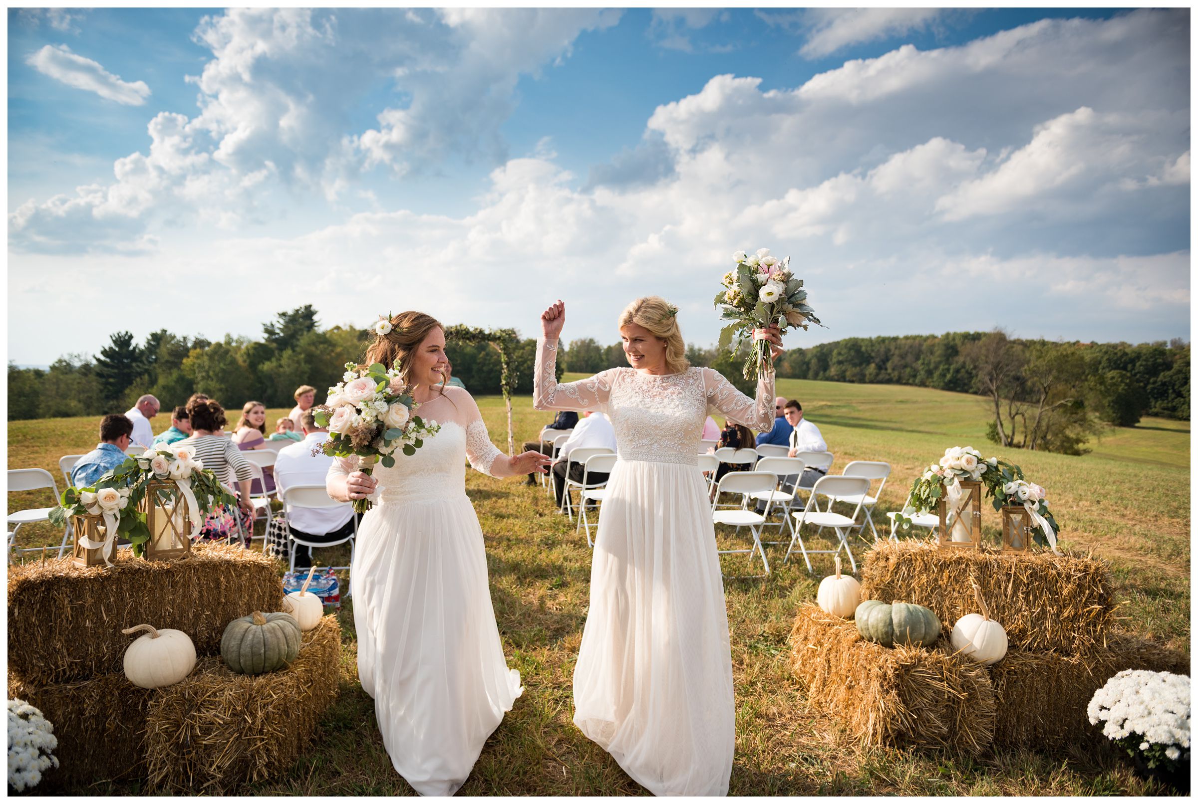 Two brides exiting their fall same-sex wedding ceremony on a farm.